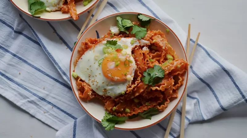 Nudelrätt med pasta, sås, stekt ägg, koriander och salladslök